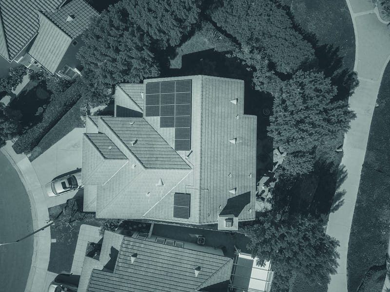 Drone view of a house with rooftop solar panels